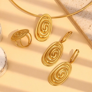 Vue macro d'une parure de bijoux dorés avec texture spirale ovale et fini vintage