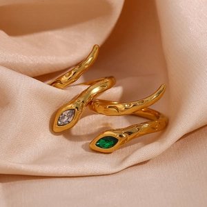 Detail of snake ring with green zircon eyes and textured hammered gold surface