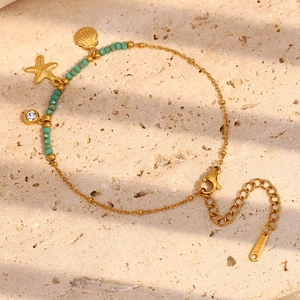 Detailed view of gold stainless steel starfish bracelet with turquoise beads and shell