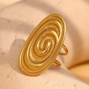 Vue détaillée d'une bague spirale dorée vintage avec texture fine sur socle en pierre