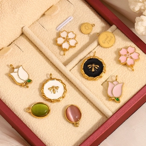Pendentifs fleurs en émail plaqués or 18 carats dans un coffret à bijoux en velours