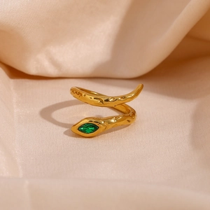 Detail showing the hammered gold snake ring with a green marquise zircon eye detail
