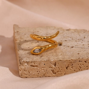 Macro detail of gold-plated snake ring with irregular texture and marquise zircon stone