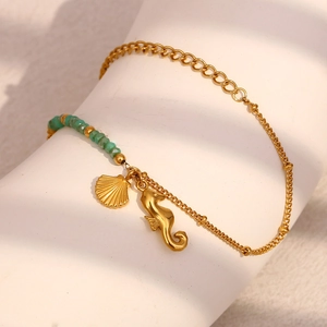 Vue détaillée du bracelet doré avec pendentifs hippocampe, coquillage et perles