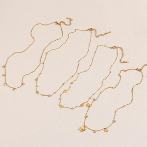 Detail of four 18K gold plated stainless steel necklaces with various elegant pendants