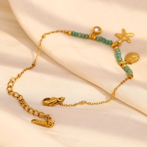 18K gold plated stainless steel starfish bracelet with turquoise beads on white satin