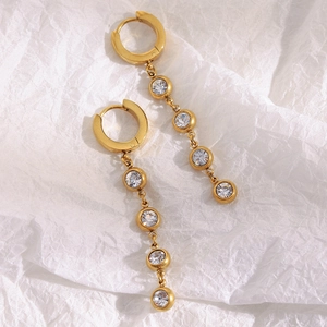 Detailed macro view of gold-plated drop earrings featuring four bezel-set round zircons