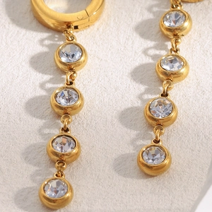 Macro shot of 18K gold plated tassel earrings featuring sparkling zircon chain links