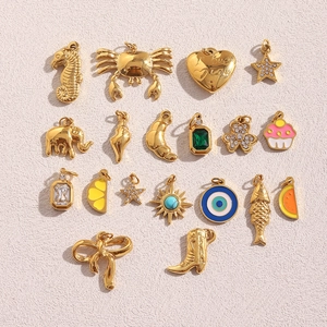 Detailed macro view of 18k gold plated charms featuring seahorse, boots, and mixed motifs