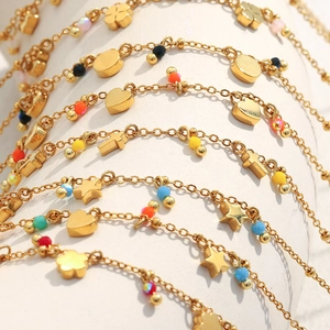 Detail of 18K gold plated stainless steel bracelets with colorful beads and charms