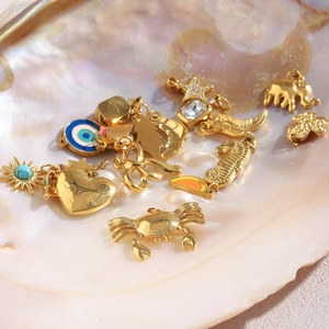 Macro shot of gold-plated stainless steel charms with turquoise and colorful inlay