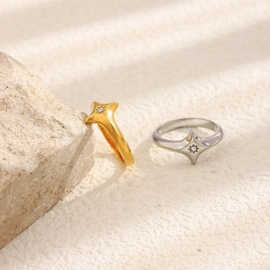 Vue détaillée des bagues en or 18 carats et argent avec étoile à quatre branches et zircon