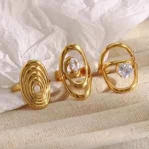 Détail macro de trois bagues vintage plaquées or serties de pierres en zircon