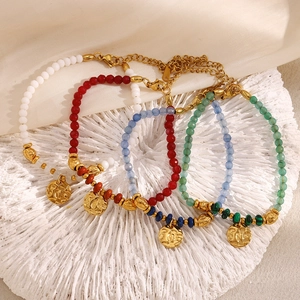 Détail de quatre bracelets en pierres naturelles colorées avec breloques pièces en or 18K