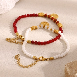Vue détaillée de bracelets en perles avec breloques dorées 18K et fermoir mousqueton robuste