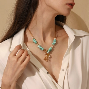 Detalle de colgantes de coral y estrella de mar en collar de perlas y turquesas