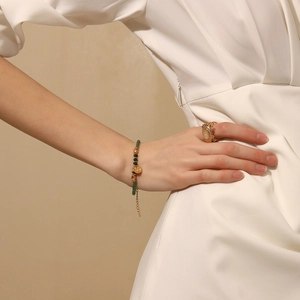 Détail du bracelet perlé plaqué or 18 carats avec pierre naturelle verte et pendentif