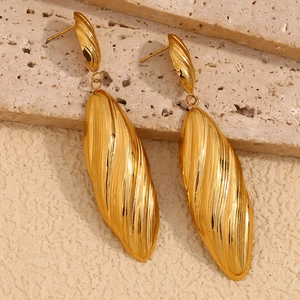 Vintage gold striped long pendant earrings on light stone tiles for women's elegant look