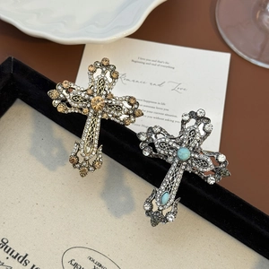 Broches croix vintage style cour royale avec strass sur un plateau à bijoux