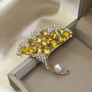 Elegante goldene Ginkgo-Brosche mit gelben Kristallen und weißer Perle auf Seide