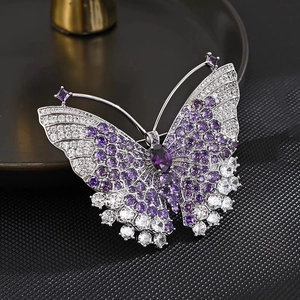 Élégante broche papillon argentée avec cristaux violets et zircons sur fond texturé