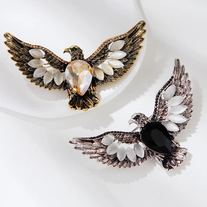 Vue détaillée de broches d'aigle vintage avec pierres ambrées et noires sur socles