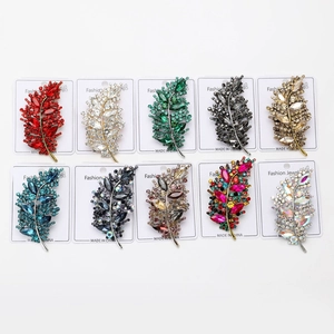 Collection of ten leaf-shaped crystal brooches in various colors on display cards