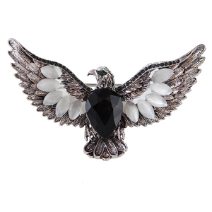 Détails d'une broche aigle en argent vintage avec pierre noire et pierres œil de chat