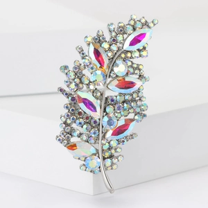 Detailed close-up of leaf-shaped brooch with colorful AB crystals on silver alloy base