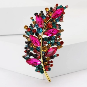 Detailed macro view of gold-tone feather brooch with vibrant multi-color rhinestones