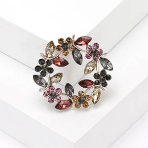 Gros plan détaillé d'une broche en forme de couronne avec des strass en cristal coloré