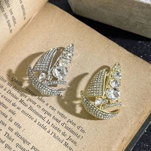 Elegant sailboat brooch set in gold and silver with sparkling crystals on vintage book