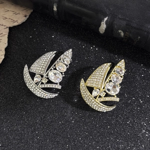 Elegant gold and silver sailboat brooches with sparkling crystals and rhinestones