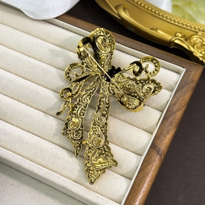 Macro view of vintage golden bow brooch back with detailed relief and pin safety clasp