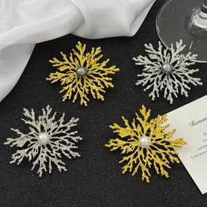 Elegant snowflake brooch set with pearl inlay in gold and silver finish on black background