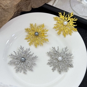 Detailed view of vintage snowflake brooches with pearls in gold and silver finish