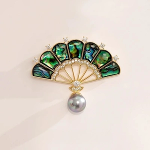 Broche éventail dorée avec nacre d'abalone irisée et une perle grise suspendue