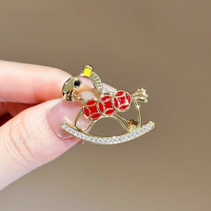 Elegant rocking horse brooch in gold with red enamel patterns and sparkling rhinestones