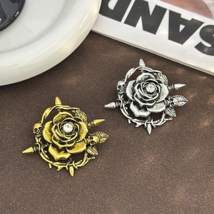 Vue macro de broches vintage en alliage avec tête de mort, rose et détails d'épée précis