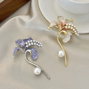 Elegante spilla a giglio con petali in smalto e perle sintetiche su sfondo seta