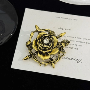 Détail d'une broche rose dorée vintage avec crâne et épines au style gothique chic