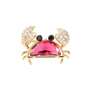 Détail d'une broche crabe avec pierre précieuse magenta et incrustation de cristaux
