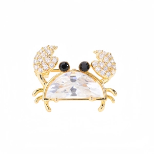Détail d'une broche crabe dorée avec cristal bleu et pavage de diamants brillants