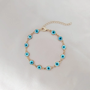 Dettaglio del bracciale Evil Eye con catena dorata e ciondoli in smalto colorati