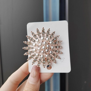 Nahaufnahme der Perlen- und Strass-Sonnenblumenbrosche mit Roségoldbeschichtung auf Karte