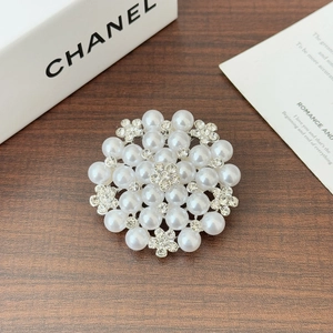 Macro shot of elegant sunflower brooch with pearls and crystals on a wooden surface