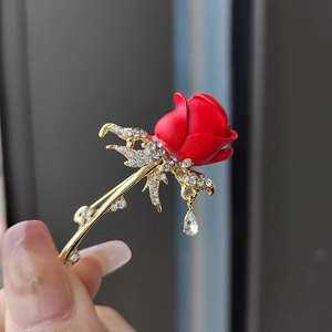 Vue détaillée d'une broche tulipe rouge élégante avec feuilles en cristal et pendentif perle