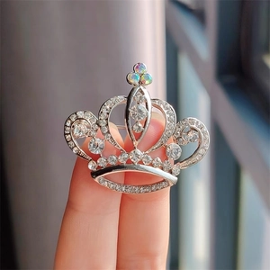 Détail de la broche couronne argentée avec strass clairs et accents arc-en-ciel