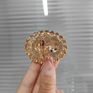 Detailed macro view showing the gold alloy brooch back with secure pin clasp mechanism