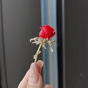 Broche rose élégante avec pétales rouges mats et cristaux étincelants sur métal doré